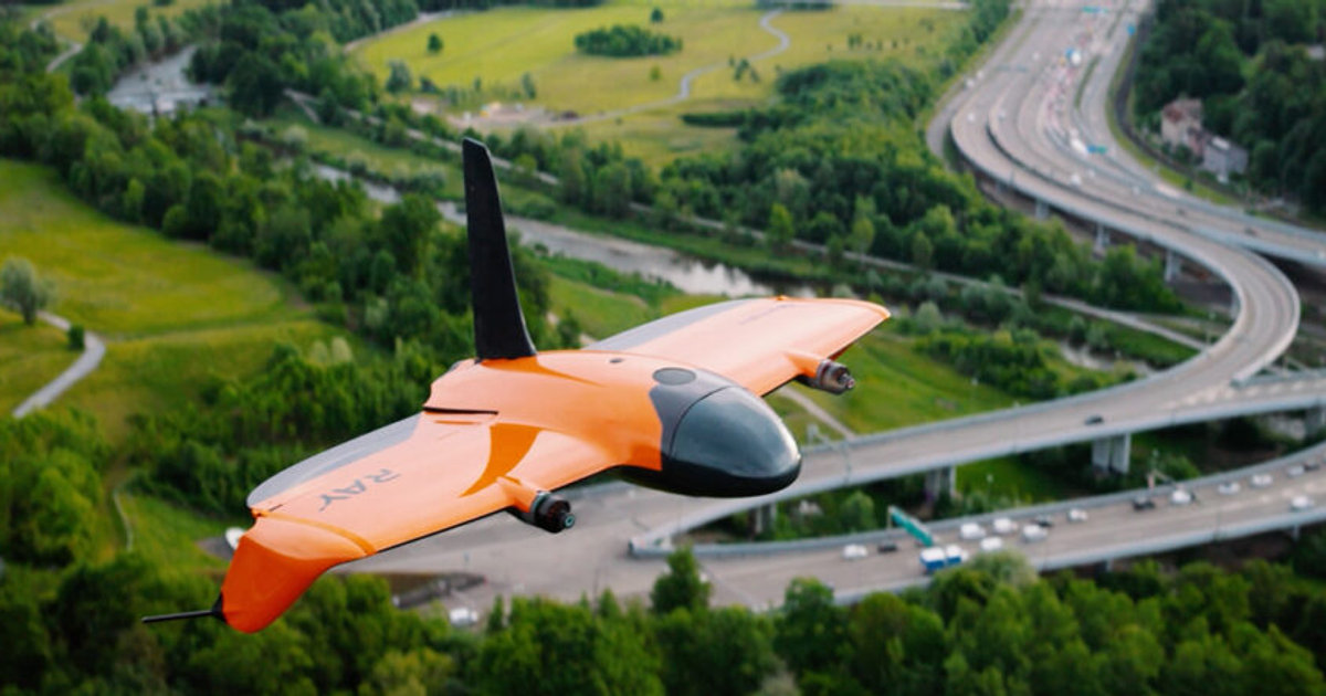 Wingtra Ray VTOL mapping drone in cruise flight over a built-up area